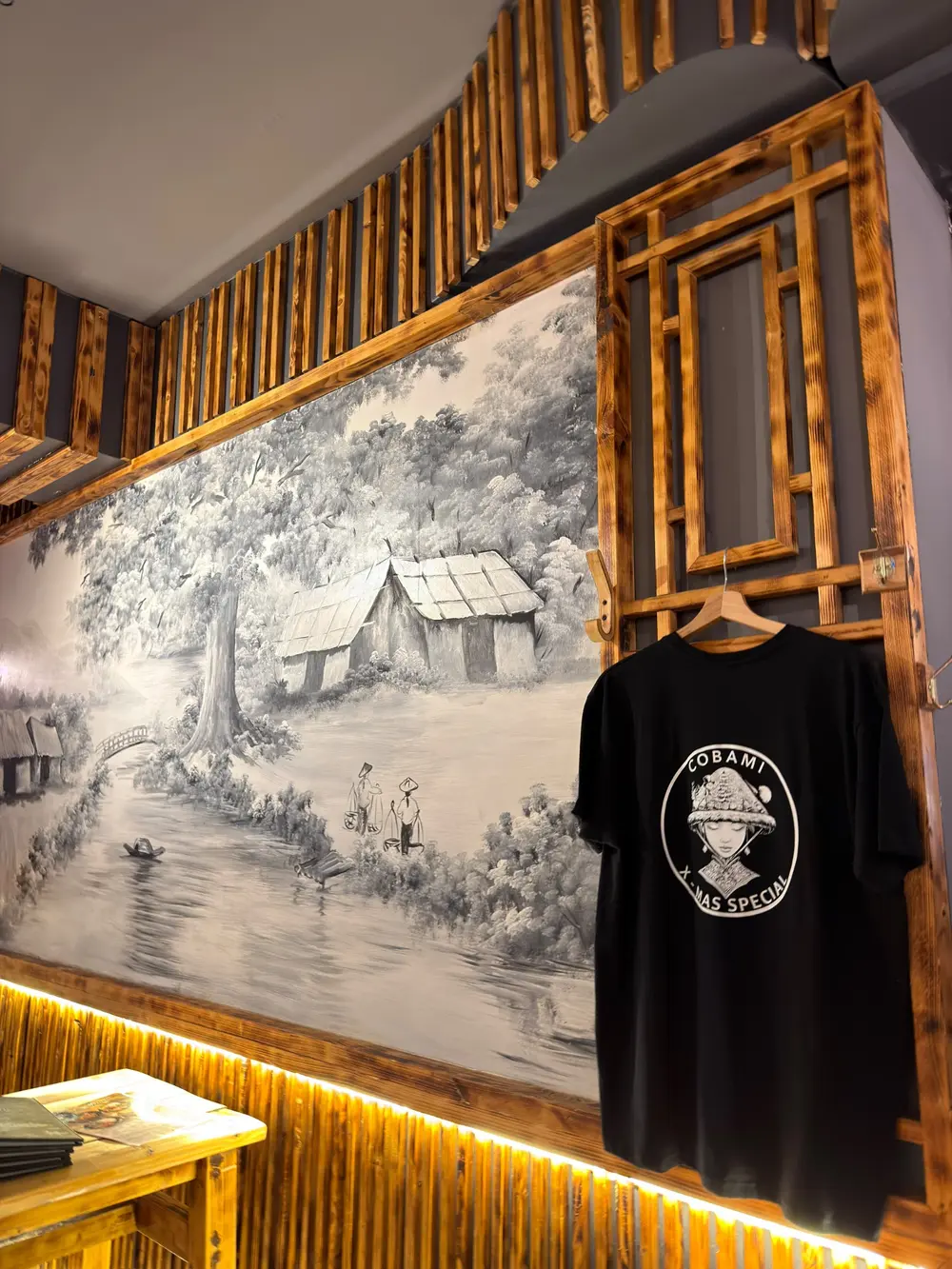 Vietnamesische Wandkunst und COBAMI-T-Shirt im Restaurant